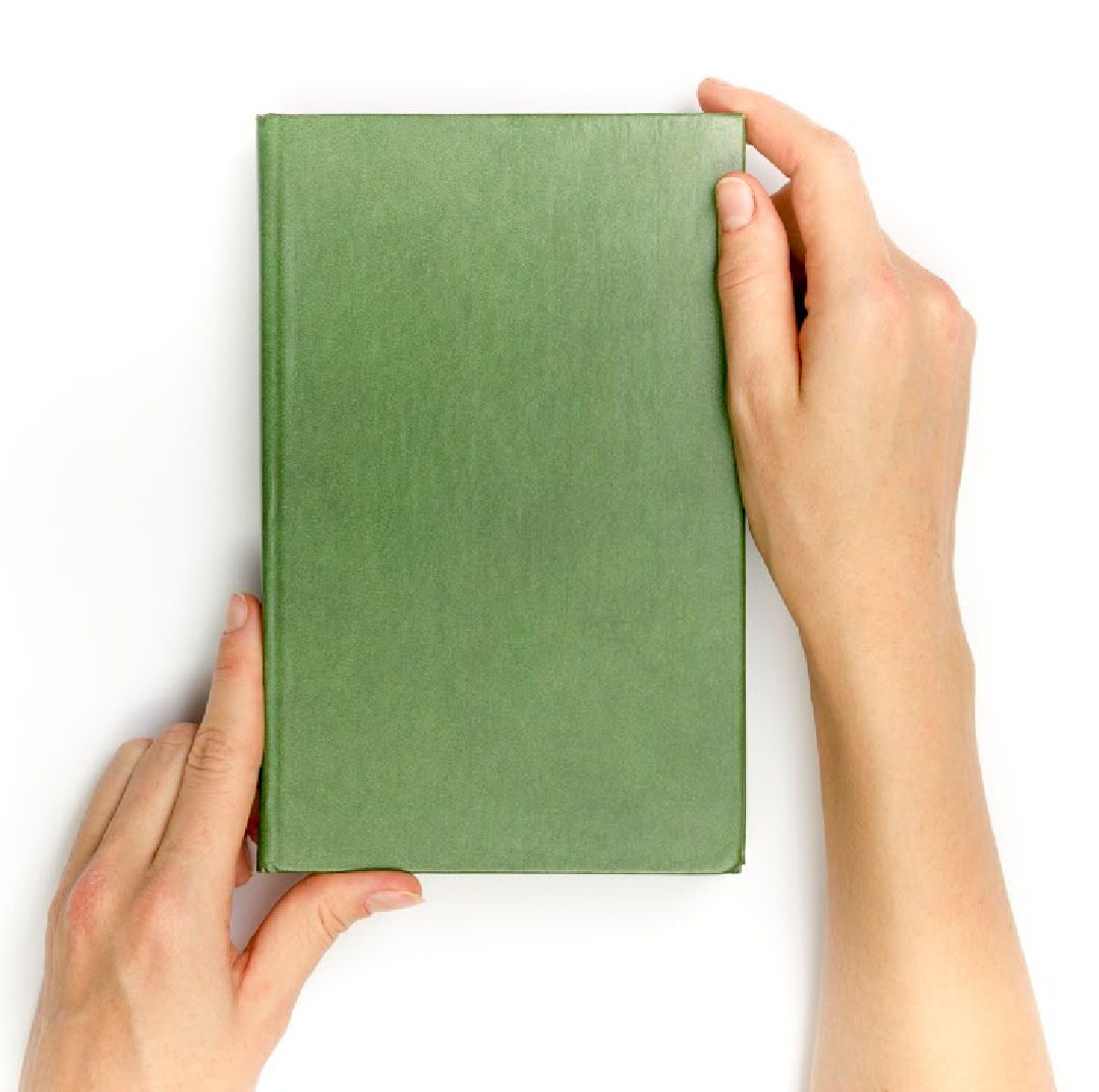 Hands hold blank red hardcover book on white background.